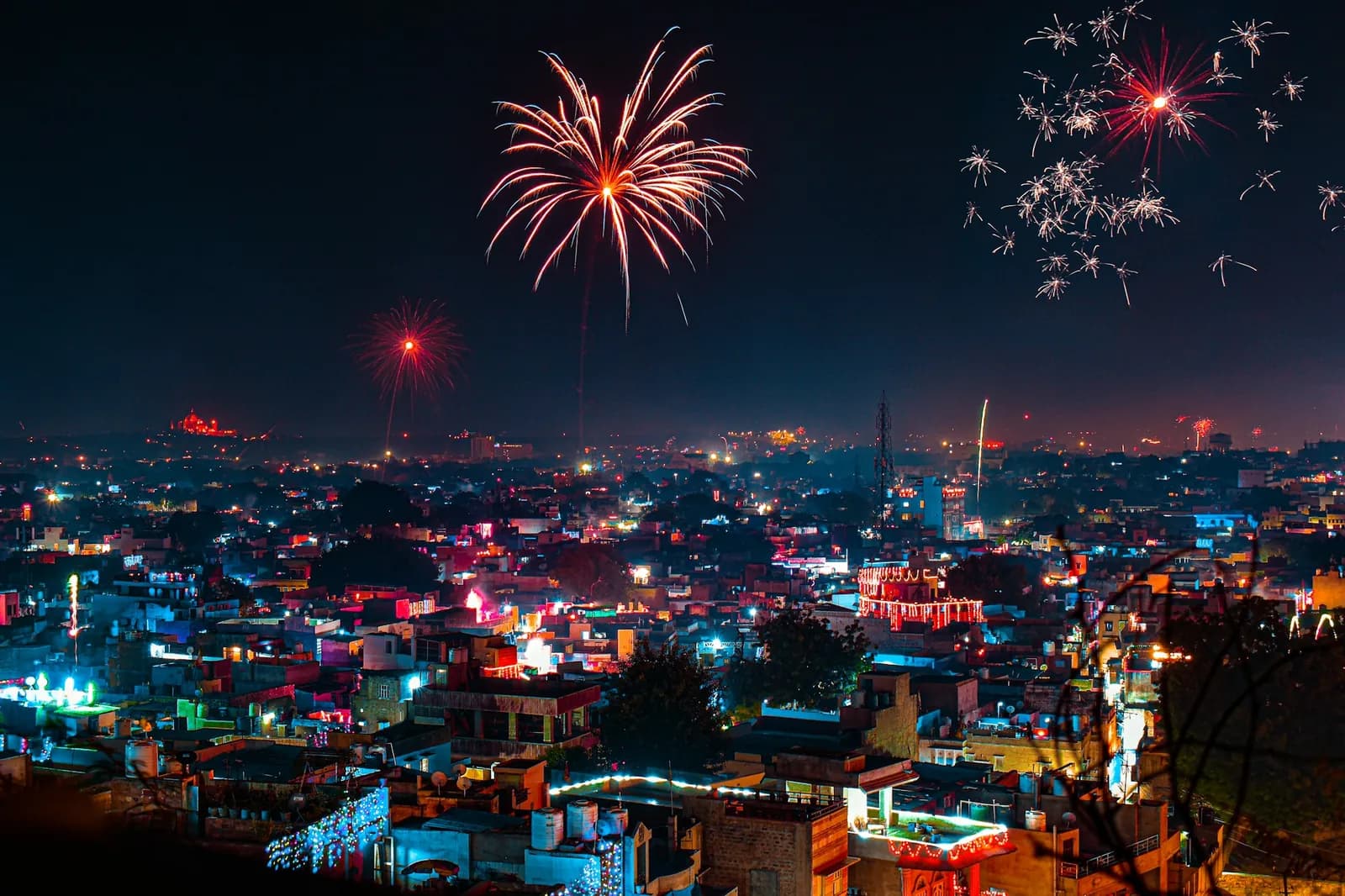 Fireworks bursting over a densely packed South Indian town at night